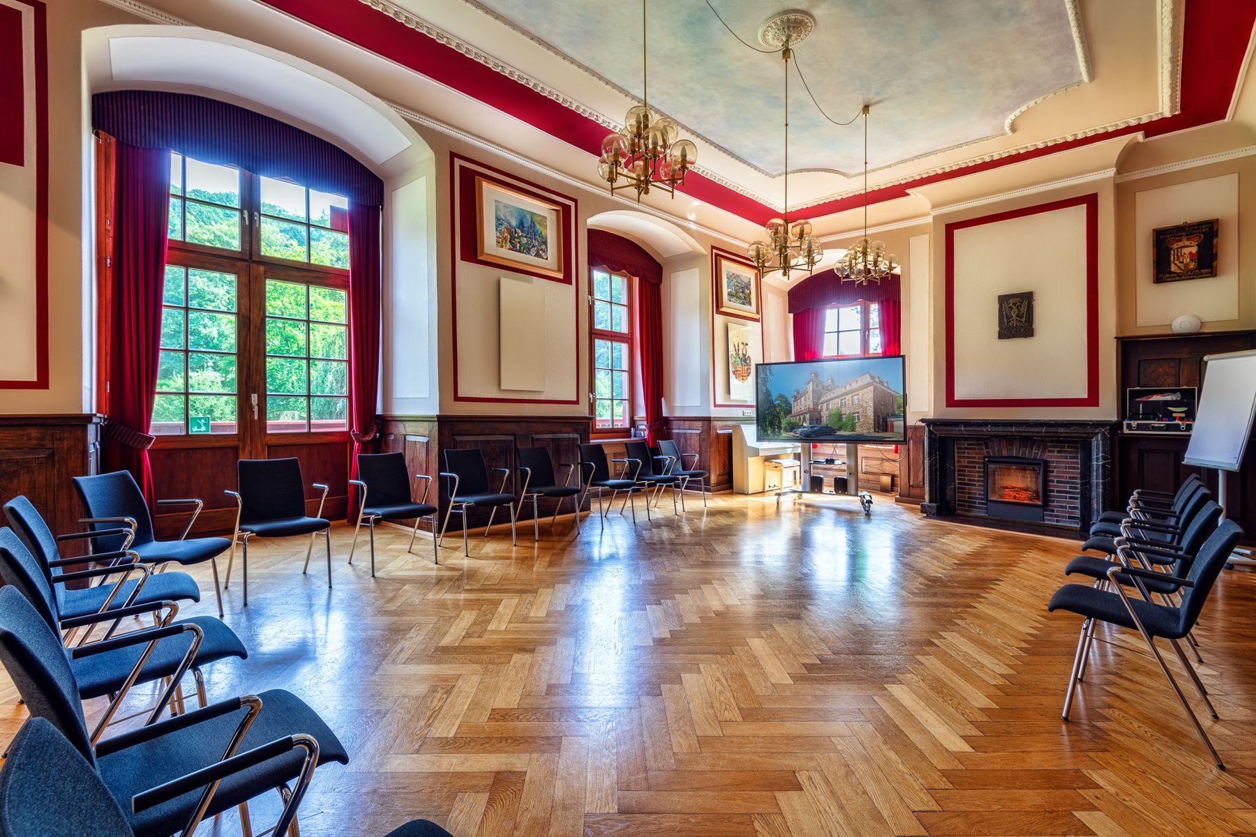 Großer Schlosssaal mit Kronleuchtern und Kamin