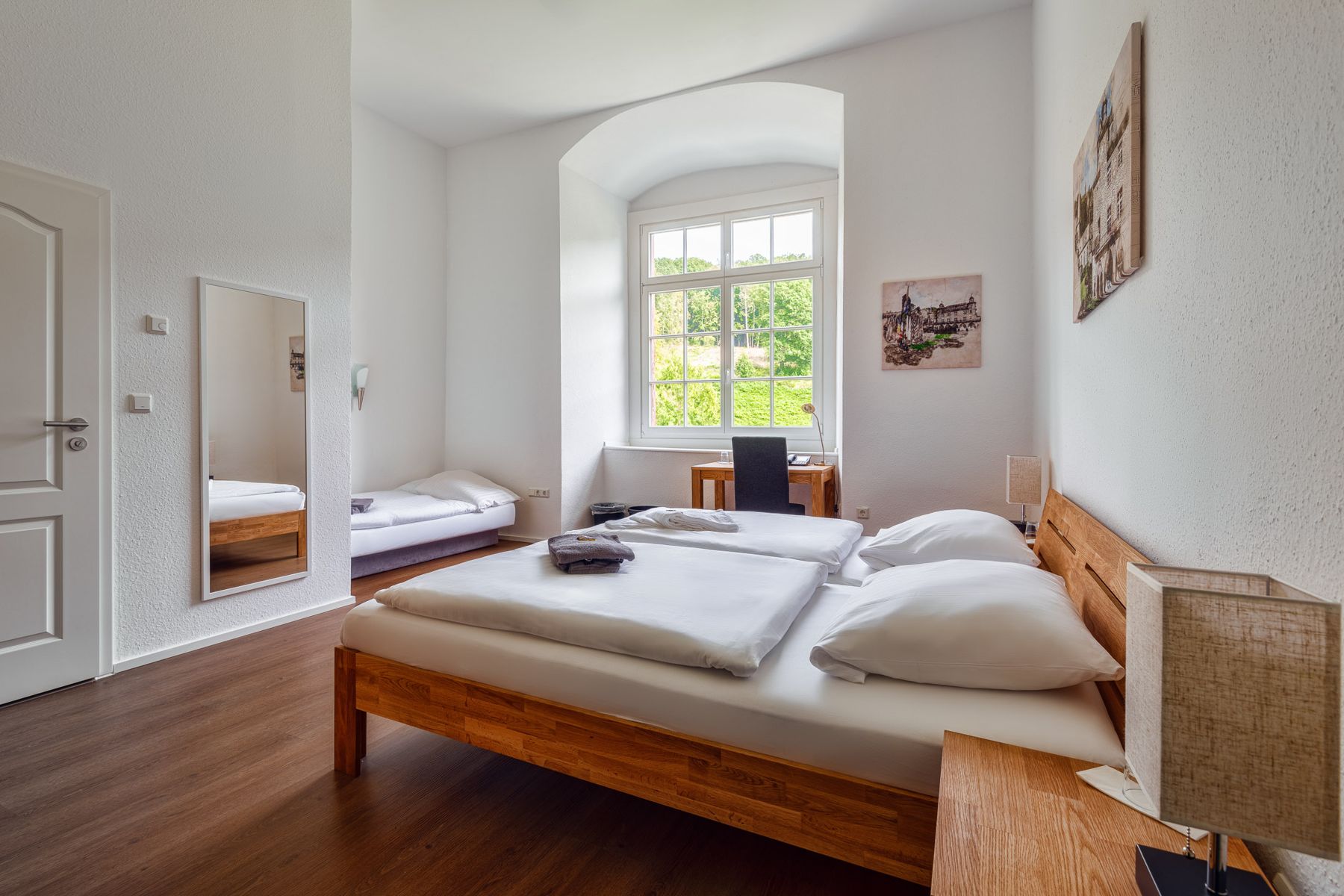 Gästezimmer mit Doppelbett, Einzelbett und Schreibtisch